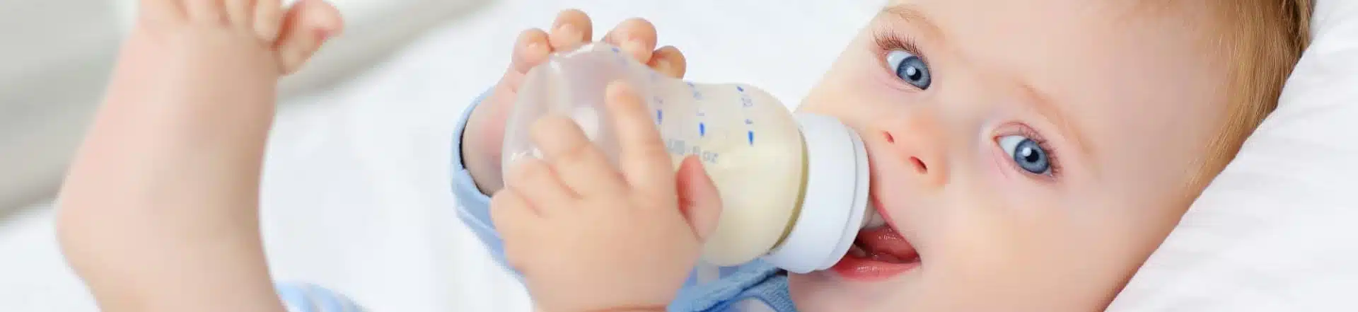תינוק מחזיק בקבוק חלב