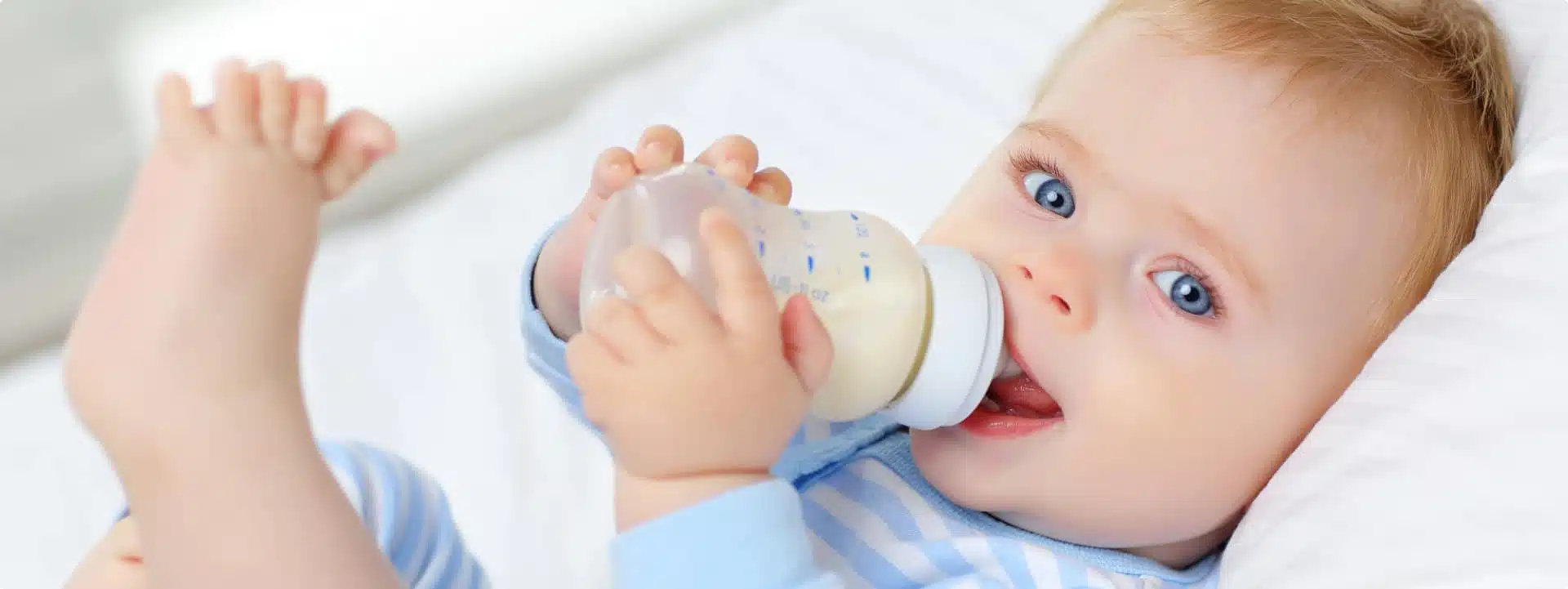 תינוק מחזיק בקבוק חלב
