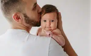 צילום של אבא מהגב מחזיק תינוק על הכתף