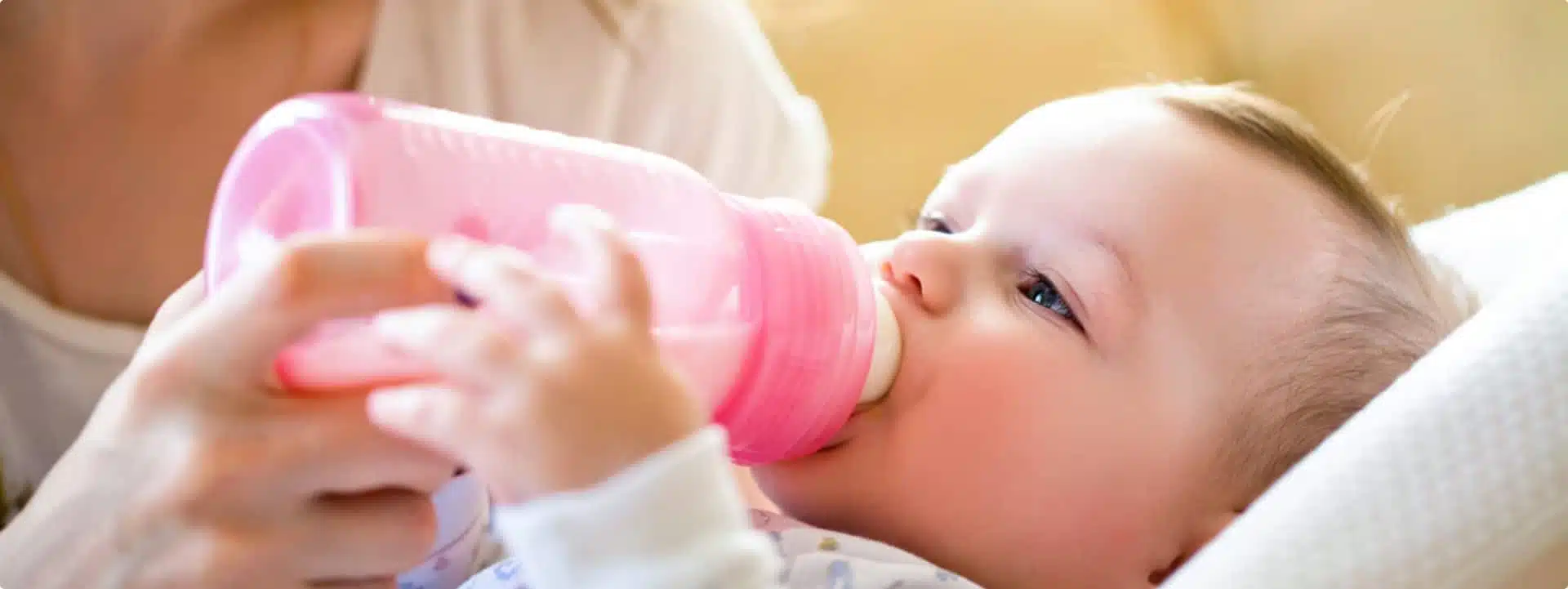 תינוק עם בקבוק חלב בפיו