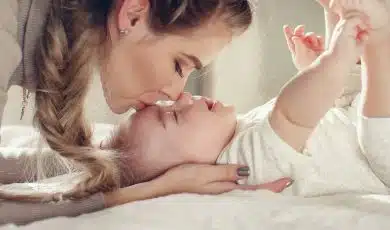 אמא מנשקת את התינוק שלה במצח
