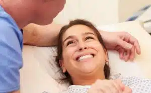 גבר מחזיק יד של אישה בחדר לידה