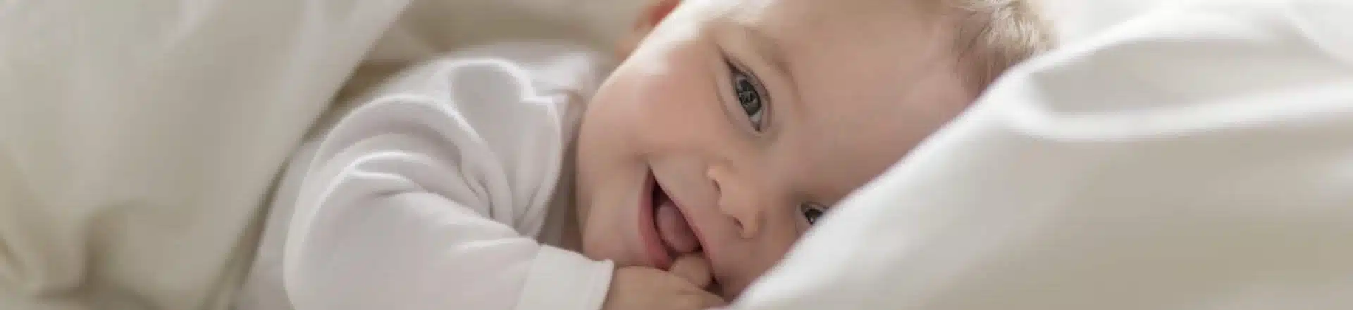 תינוק מחייך במיטה