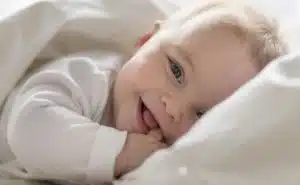 תינוק מחייך במיטה