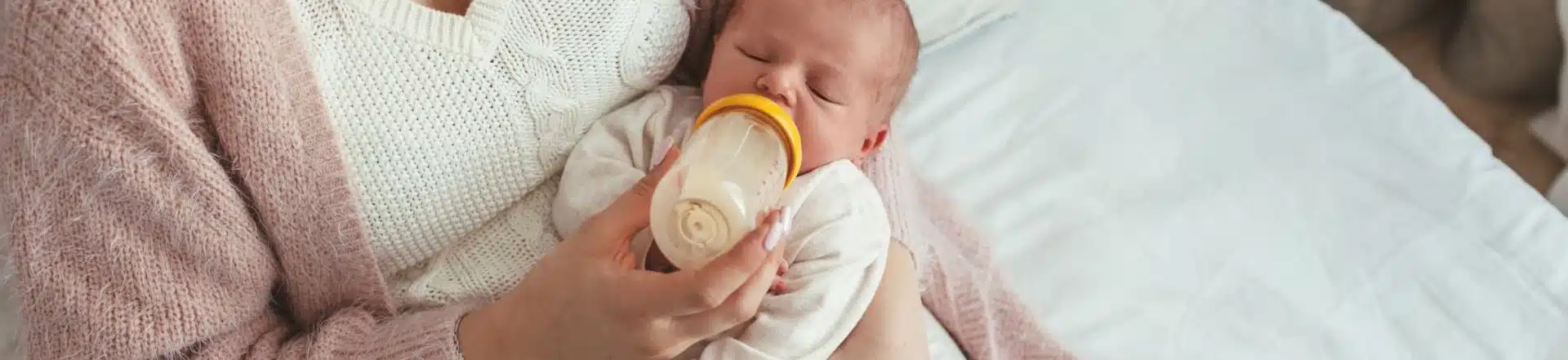 אמא מאכילה את תינוקה בבקבוק חלב
