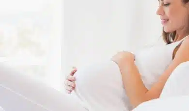 אישה בהריון מחזיקה את הבטן שלה