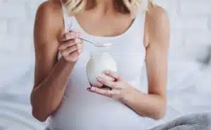 אישה בהריון אוכלת יוגורט