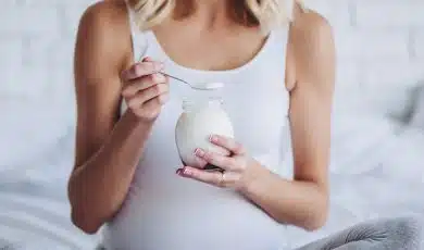 אישה בהריון אוכלת יוגורט
