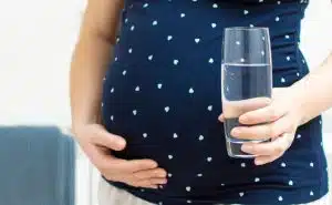 אישה בהריון מחזיקה כוס