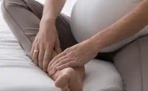 אישה בהריון מחזיקה את הרגל