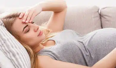 אישה בהריון שוכבת על הספה