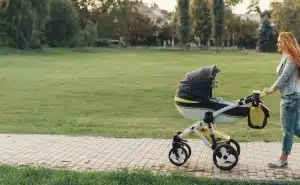 אמא מטיילת עם עגלת תינוק בפארק