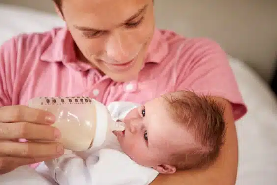 אבא מאכיל את בנו בבקבוק חלב