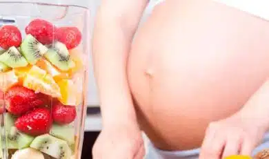 אישה בהריון חותכת פירות ולידה כלי עם פירות