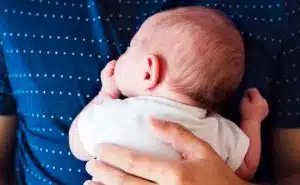 תינוק שוכב על הבטן של אביו