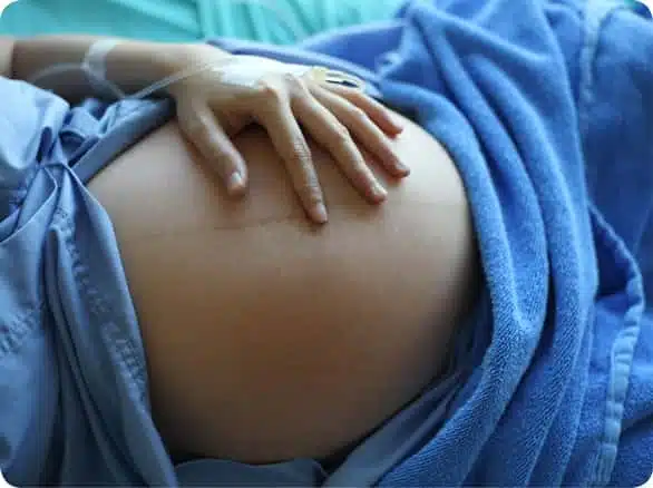 תקריב לבטן של אישה בהריון בבית החולים