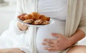 אישה בהריון מחזיקה צלחת עם עוגיות