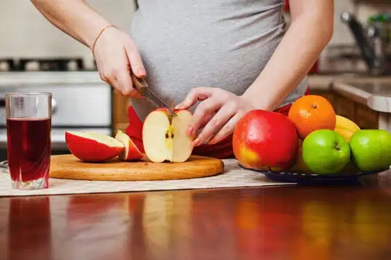אישה בהריון חותכת פירות