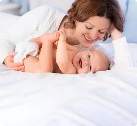 תינוק ואימו משחקים במיטה