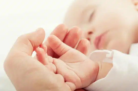 קלוזאפ על יד של תינוק ישן מונחת על יד של אימו