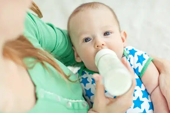 אמא מאכילה תינוןק עם בקבוק חלב