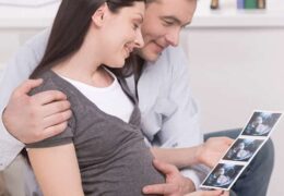 זוג צעיר מעיין בתוצאות בדיקת אולטרסאונד עם תמונת עובר