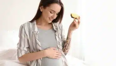 אישה בהריון אוכלת אננס