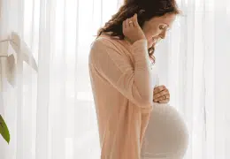 אישה בהריון ליד חלון