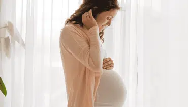 אישה בהריון ליד חלון