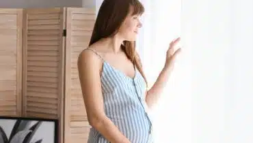 אישה בהריון מסתכלת מהחלון