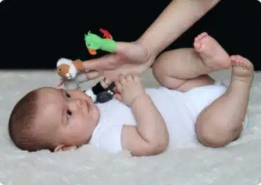 אמא משחקת עם בובות אצבע מול התינוק