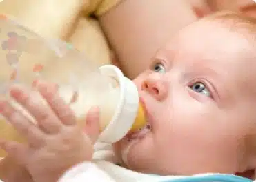 תינוק שותה בקבוק חלב
