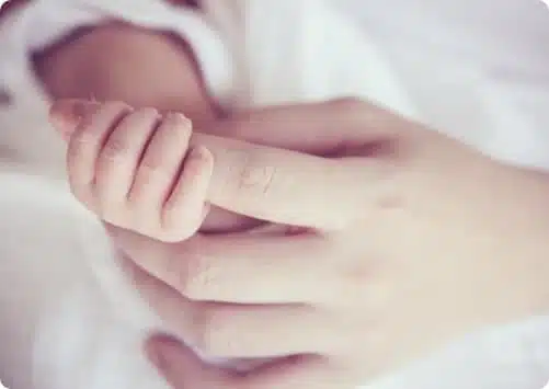 יד של אישה מחזיקה בידו של תינוק
