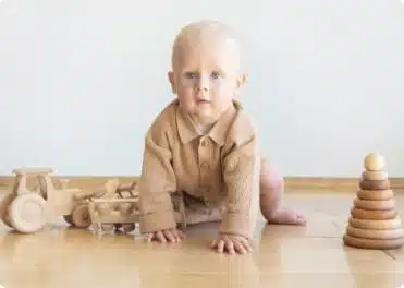 תינוק יושב על הרצפה ומשחק