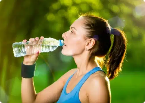 בחורה ספורטיבית שותה מים מהבקבוק