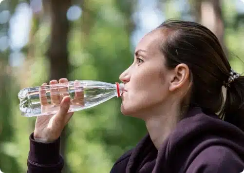 בחורה ספורטיבית שותה מים מהבקבוק