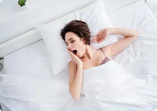 אישה מפהקת במיטה