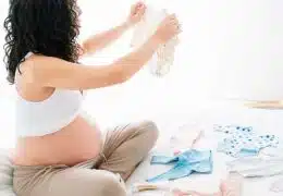 אישה מסדרת את הבגדים לקראת התינוק